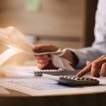 closeup-economist-using-calculator-while-going-through-bills-taxes-office.jpg