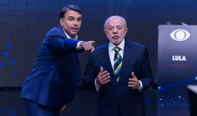 No debate, Flávio adota estratégia de se posicionar e fazer negações ao fundo de falas de Lula, que se irrita